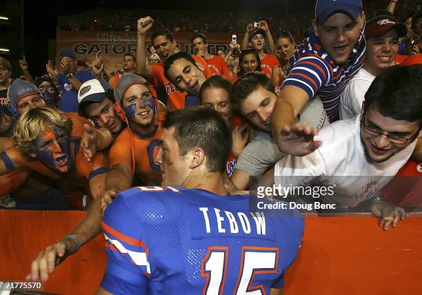 Fans line up and reach out to touch quarterback Tim Tebow of the University of Florida Gators after defeating the Southern Miss Golden Eagles at Ben...