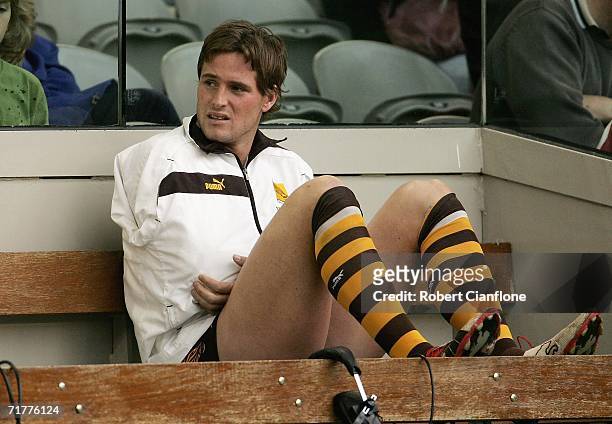 Trent Croad of the Hawks sits on the bench after he was injured during the round 22 AFL match between the Hawthorn Hawks and the Geelong Cats at the...