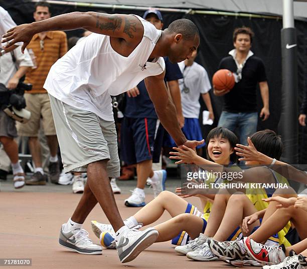 S Los Angeles Lakers star shooting guard Kobe Bryant greets junior basketball players upon his arrival for his basketball clinic, "Kobe81 Asia Tour...