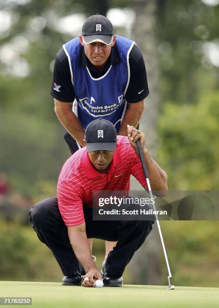 Tiger Woods lines up a putt with his caddie Steve Williams on the 15th green during the final round of the Deutsche Bank Championship at the TPC of...