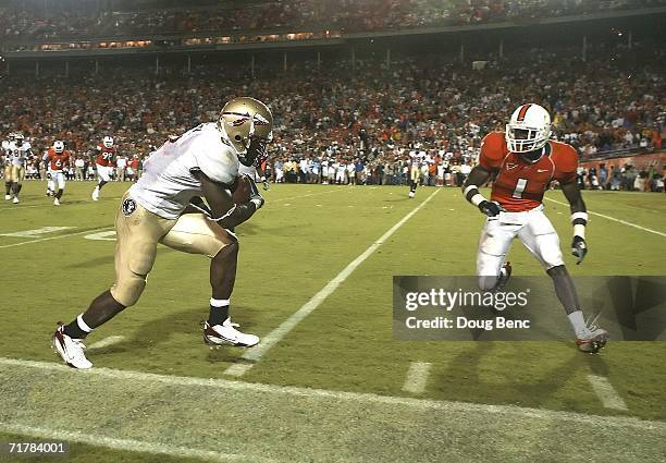Running back Antone Smith of the Florida State Seminoles prepares to collide with safety Kenny Phillips of the University of Miami Hurricanes at the...