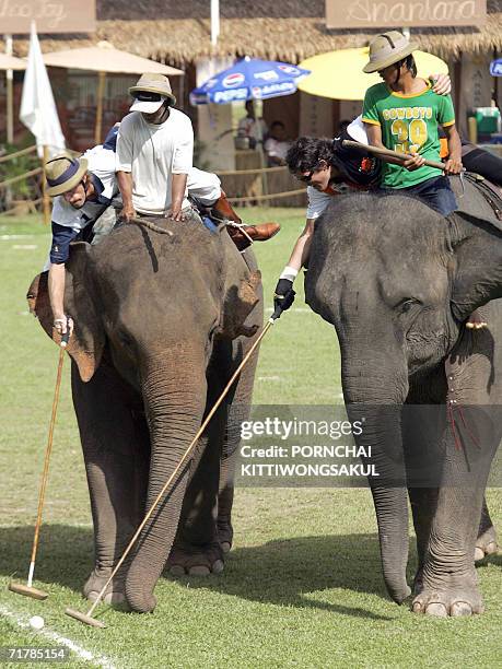 Polo player from Germany sit on an elephant while battling for the ball with a player from Australia during the King's Cup Elephant Polo match near...