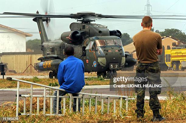 Kinshasa, Democratic Republic of the Congo: A German helicopter is watched by a Congolese workman and a EUFOR soldier as it prepares to take off from...