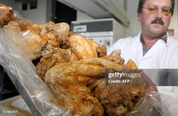 Picture taken 01 September 2006 shows veterinary inspector Hermann Schreiber keeping up a proof of chicken meat at the Bavarian State Office of...