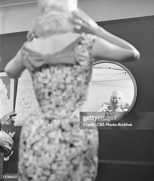 American actress Jayne Mansfield is seen in a mirror at home as she prepares for her appearance on the CBS television program 'Person to Person,' May...