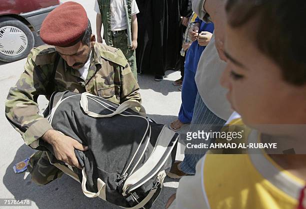 An Iraqi policeman inspects 05 September 2006 the content of a hand bag on the outskirts of the holy city of Karbala, 110 kilometers south of...