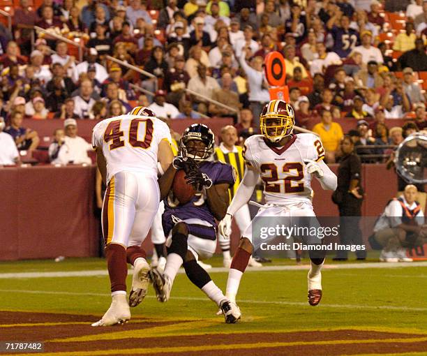 Wide Receiver Mark Clayton , of the Baltimore Ravens, catches a touchdown pass in front of safety Adam Archuleta and cornerback Carlos Rogers , of...