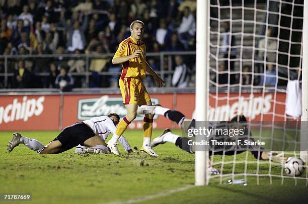 Mario Gomez of Germany scores the first goal while Cosmin Moti and Mihai Minca of Romania look on d during the UEFA Under 21 championship qualifier...