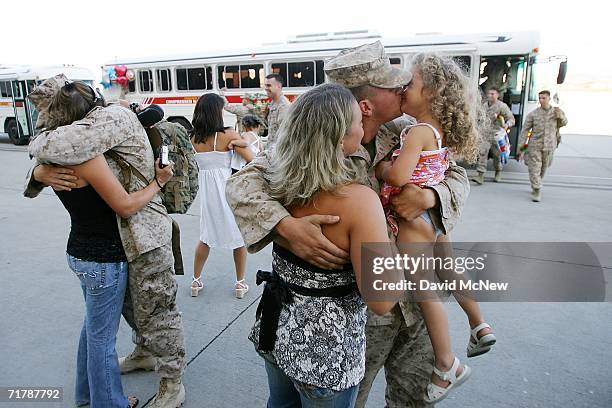 Corporal David Boeken embraces his wife Nickole and Lance Corporal Matthew Hoage is greeted by his wife Misty and three-year-old daughter Madelyn as...