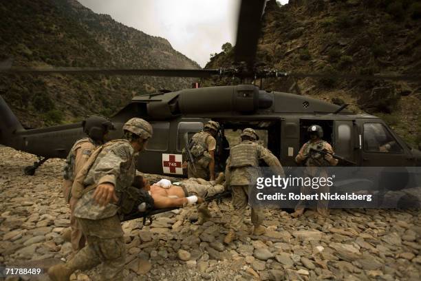 Three wounded US Army soldiers from the 10th Mountain Division are moved for evacuation to a helicopter in Kamdesh, Nuristan August 27 eastern...
