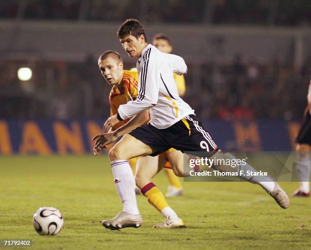 Cosmin Moti of Romania views for the ball with Mario Gomez of Germany during the UEFA Under 21 championship qualifier between Germany and Romania at...