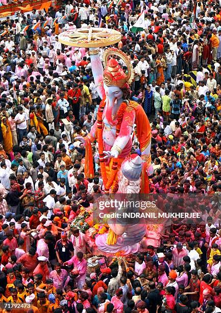 Indian devotees throng a major road as a huge idol of the elephant headed Hindu God Lord Ganesha is paraded through the streets of Mumbai, 06...