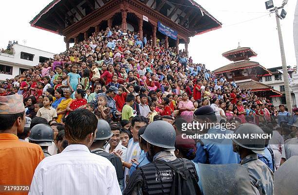 Nepalese devotees gather to pay homage to Kumari, a pre-pubescent girl revered by many in Nepal as a living goddess, as security forces keep watch on...