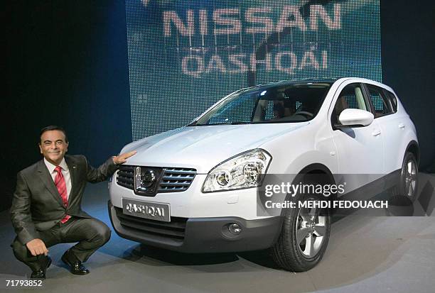 Carlos Ghosn, head of the French and Japanese automakers Renault and Nissan poses with "Qashqai" crossover, the new compact Nissan vehicle, 06...