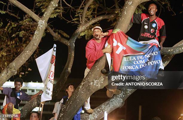 Supporters of Brazilian President Luiz Inacio Lula da Silva climb a tree to get a better sight of their candidate 01 September, 2006 during a meeting...