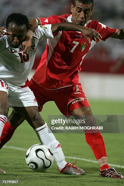 Dubai, UNITED ARAB EMIRATES: Emirati player Ismail Matar fights for the ball with Jordanian opponent Khaled Amer , during their Asian Cup Qualifiyng...