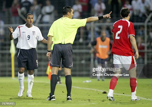 Theo Walcott of England argues with the French referee S Lannoy after his challenge on Stefan Lichtsteiner of Switzerland during the UEFA Under...