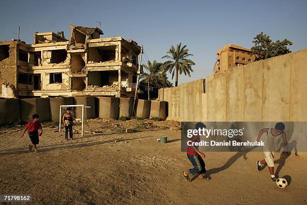 Young Iraqi boys play soccer amongst protective blast walls on September 6, 2006 in Baghdad, Iraq. It was here on October 14, 2005 two suicide...