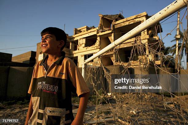 Young Iraqi boy looks on at his friends playing soccer amongst protective blast walls on September 6, 2006 in Baghdad, Iraq. It was here on October...