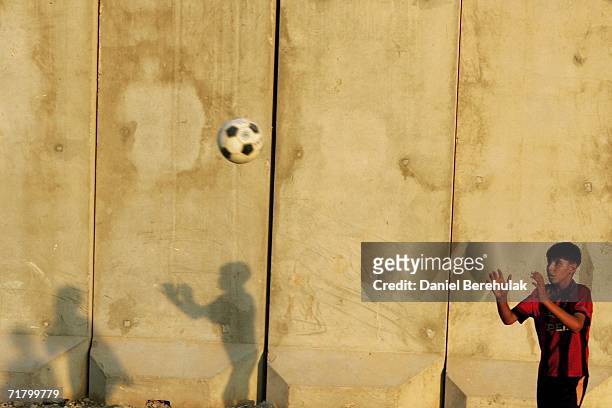 Young Iraqi boys play soccer amongst protective blast walls on September 6, 2006 in Baghdad, Iraq. It was here on October 14, 2005 two suicide...