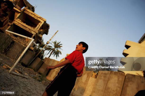 Young Iraqi boy plays soccer amongst protective blast walls on September 6, 2006 in Baghdad, Iraq. It was here on October 14, 2005 two suicide...