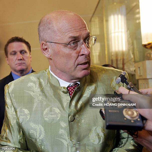 Treasure Secretary Henry Paulson, dressed in an official Vietnamese APEC suit, talks to media prior at the opening of a meeting of the Asia-Pacific...