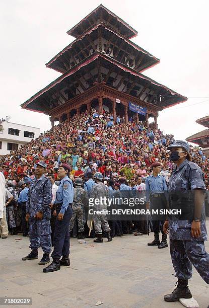 Nepalese devotees gather to pay homage to Kumari, a pre-pubescent girl revered by many in Nepal as a living goddess, as security forces keep watch on...