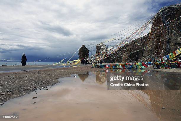 Tibetan man walks past Prayer Flags beside the Namtso Lake on August 27, 2006 in Dangxiong County of Lhasa, Tibet Autonomous Region, China. Chinese...