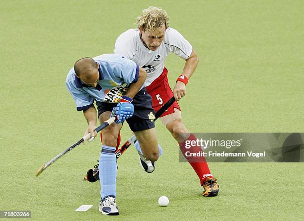 Viren Rasquinha of India tussels for the ball with Richard Alexander of England during the World Cup Pool B match between India and England at the...