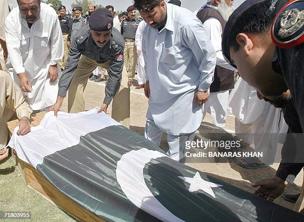 Pakistani policemen drap the coffin of Police officer Khalid Garamkani, with a national flag prior to his funeral in Quetta, 07 September 2006. A...