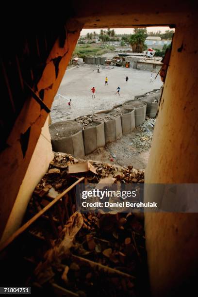 Young Iraqi boys play soccer amongst protective blast walls on September 7, 2006 in Baghdad, Iraq. It was here on October 14, 2005 that two suicide...