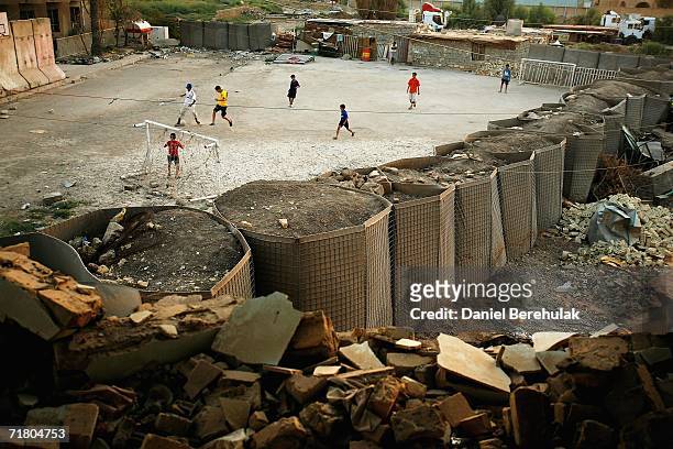 Young Iraqi boys play soccer amongst protective blast walls on September 7, 2006 in Baghdad, Iraq. It was here on October 14, 2005 that two suicide...