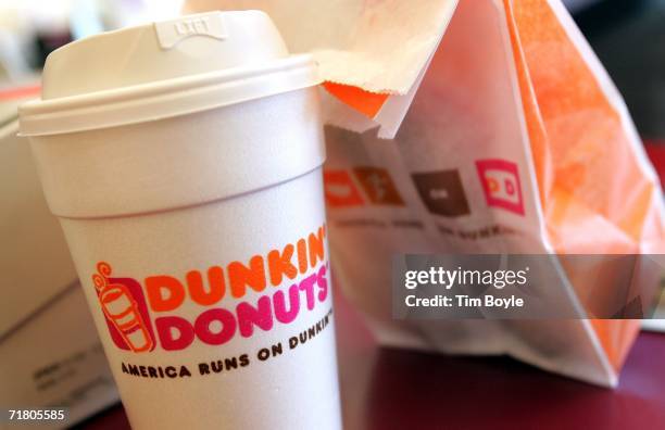 Cup of Dunkin' Donuts coffee and a donut bag sit on a counter September 7, 2006 in Chicago, Illinois. In an effort to compete with Starbucks in the...