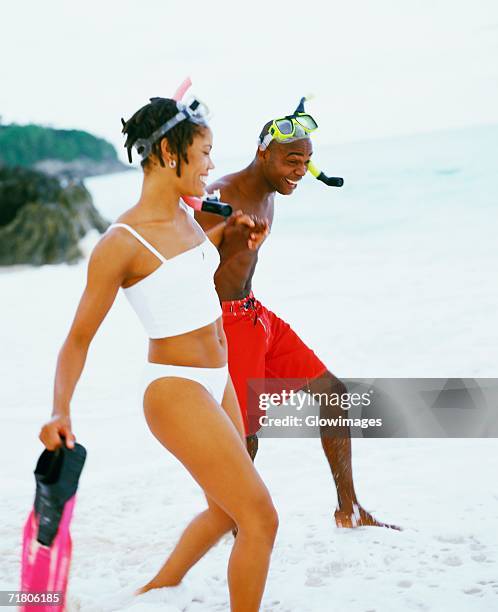 side profile of a young couple walking on the beach, bermuda - bermuda snorkel stock pictures, royalty-free photos & images