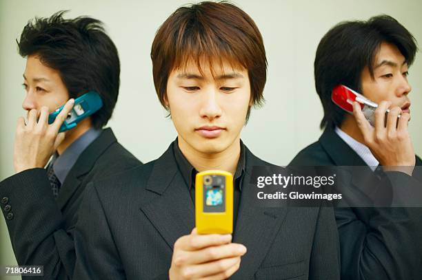 three businessmen using mobile phones - feature phone stockfoto's en -beelden