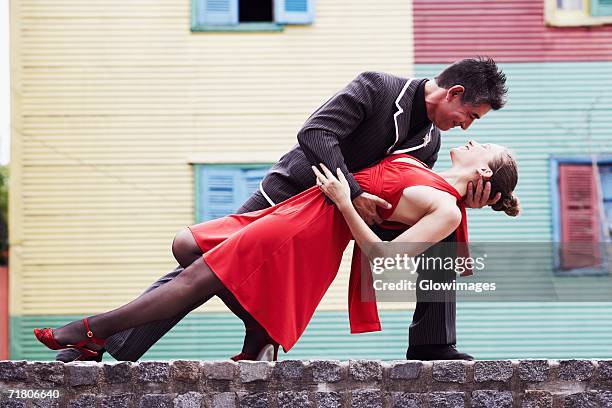 mature man and a mid adult woman tangoing - tangoing stock pictures, royalty-free photos & images