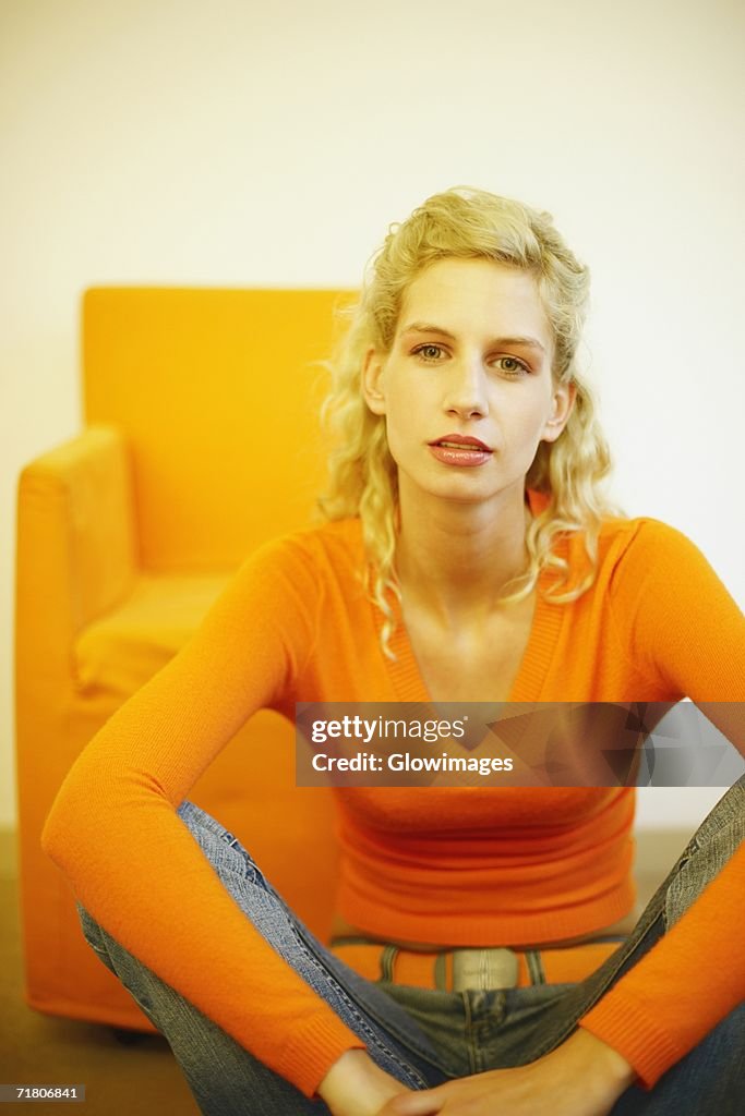 Portrait of a young woman sitting on the floor