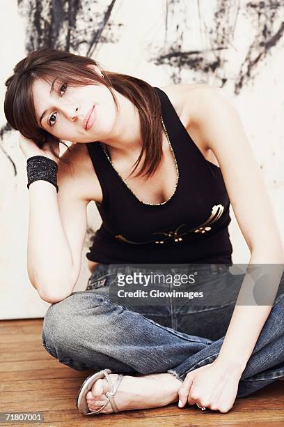 portrait of a young woman sitting on the floor - fashion woman floor cross legged stock pictures, royalty-free photos & images