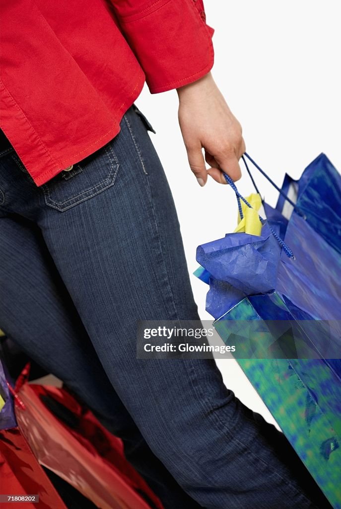 Low section view of a woman holding shopping bags