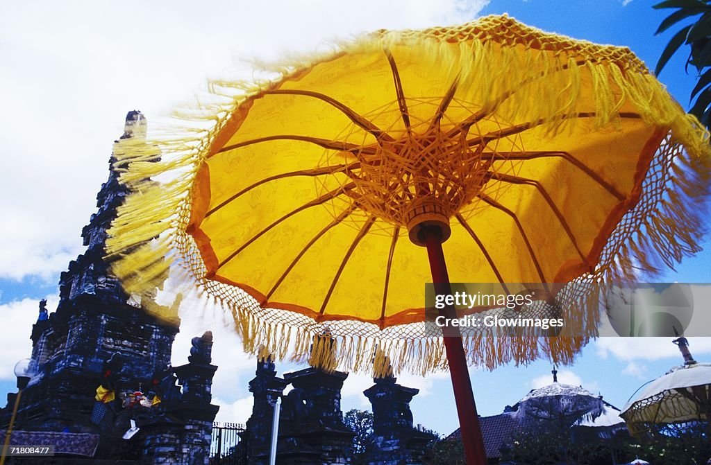 Low angle view of a sunshade in front of a temple, Bali, Indonesia