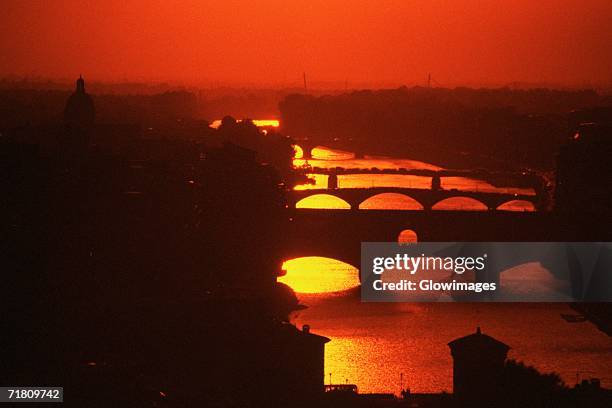 silhouette of an arch bridge across a river, ponte echo, arno river, florence, tuscany, italy - ponte vecchio bildbanksfoton och bilder