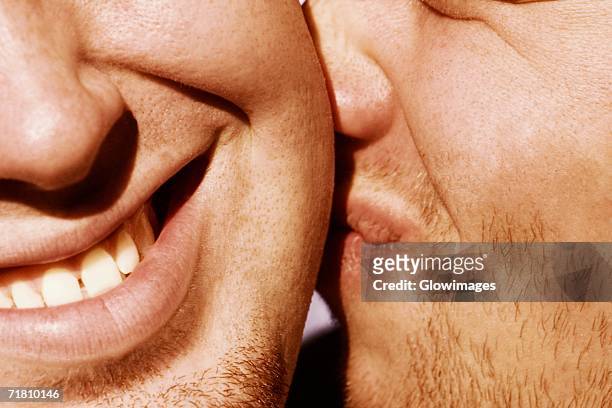 close-up of a man kissing another man - cheek - fotografias e filmes do acervo
