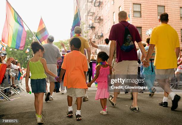 rear view of a group of people walking at a gay parade - gay pride parade stockfoto's en -beelden