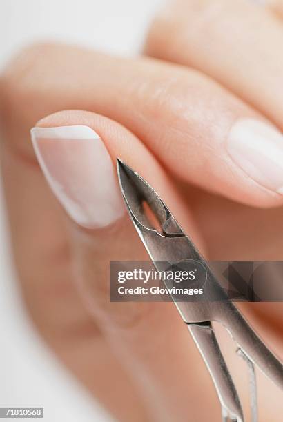 close-up of a woman's hand using a nail scissor - nail scissors stock pictures, royalty-free photos & images