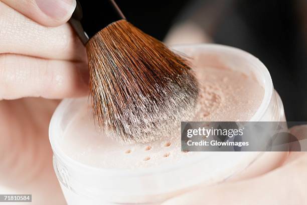 close-up of a woman's hand holding a pot of face powder and a make-up brush - poder stock pictures, royalty-free photos & images