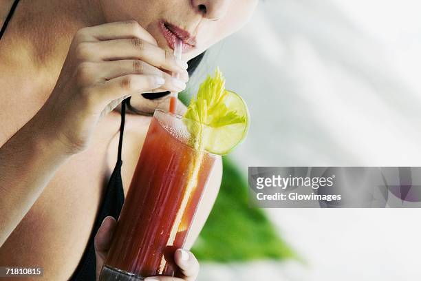 close-up of a young woman drinking a bloody mary - bloody mary stock pictures, royalty-free photos & images