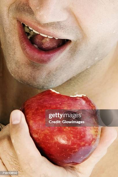 close-up of a young man eating an apple - pomme croquée photos et images de collection