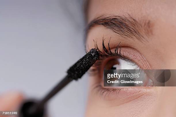 close-up of a young woman applying mascara - applying mascara stock pictures, royalty-free photos & images