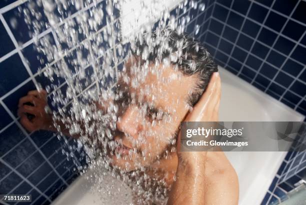 close-up of a young man in the shower - douche stockfoto's en -beelden
