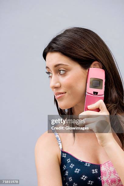 close-up of a teenage girl using a mobile phone and smiling - feature phone stockfoto's en -beelden